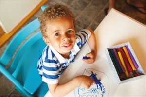 Child drawing with crayons, illustrating fine motor skill development