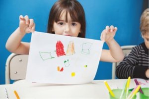 Child showing a drawing, representing progression in drawing skills