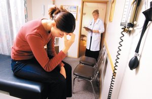 Image of a person in a medical setting, illustrating health problems potentially related to debt stress