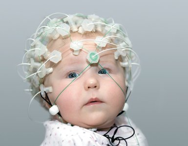 Infant with EEG cap measuring brain activity