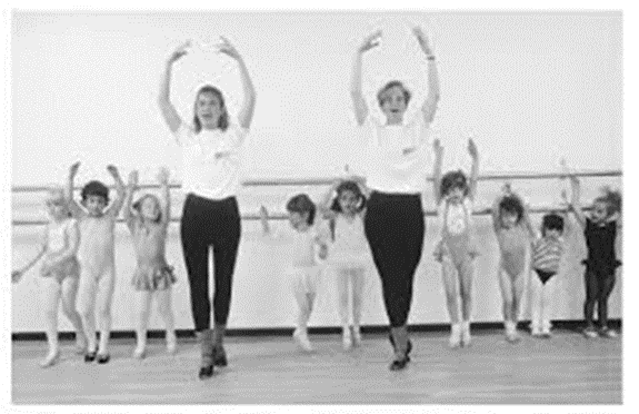 Children imitating dance moves from instructors