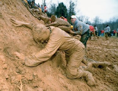 Cadets crawling through mud as part of a severe initiation