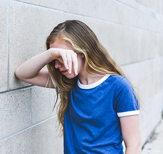 Teen sitting alone, representing feelings of isolation and stigma
