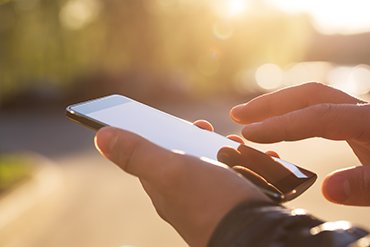Person using a smartphone, symbolizing access to crisis support via phone or text