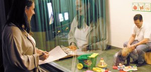 Researcher observing a participant through a one-way mirror