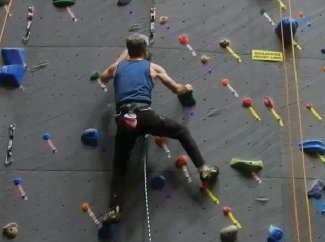 Older adult climbing a rock wall, illustrating physical activity in middle and late adulthood