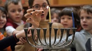 Children lighting a menorah for Hanukkah