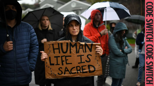 Protest with sign reading 'Human Life is Sacred'