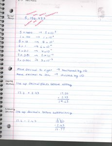Notebook page with scientific notation and decimal operations